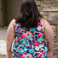 Photo of back view of plus size woman wearing floral & paisley DIBY Club Amelia one-piece swimsuit