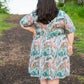 Back view of Emmeline in plus size featuring elbow-length sleeves and knee-length skirt. 