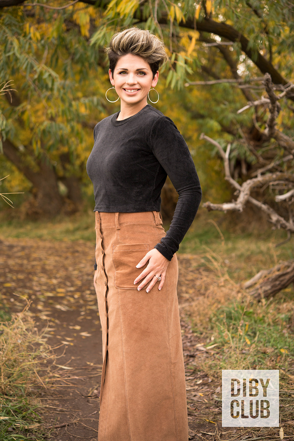 Photo of woman standing on a trail wearing a black long sleeve velvety shirt with a brown corduroy maxi-lengthDIBY Club Anna Button-Up Skirt