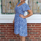 The Sojourner Bias Dress with a v-neck and mid-thigh high-low hem. 