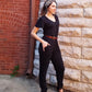 Stevie jumpsuit in misses pattern in all black fabric with short sleeves, slat pockets, and tapered leg. 